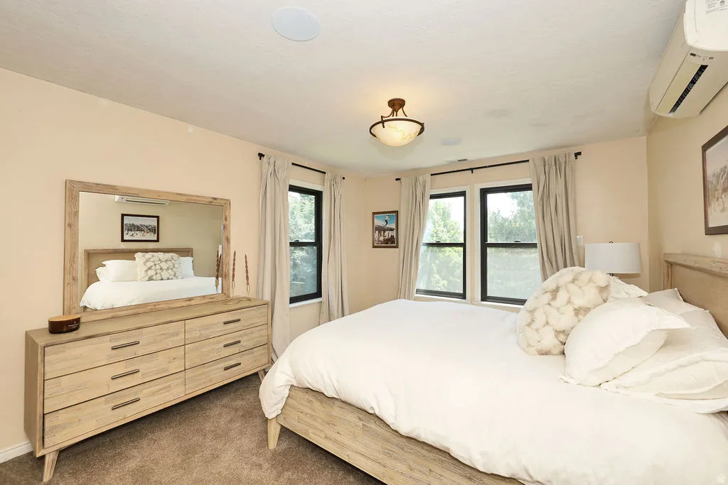 2nd floor primary Bedroom featuring a ceiling-mounted light fixture, recessed ceiling speakers, and dual windows with dark trim
