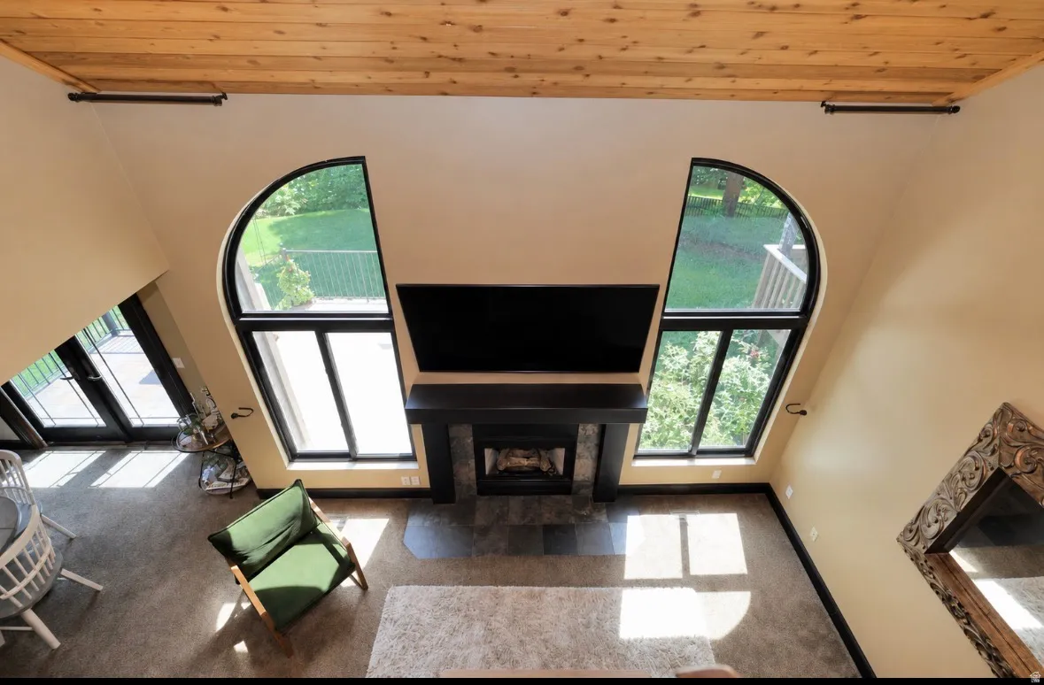High ceilings with wood-plank finish and black accent beams create an expansive atmosphere