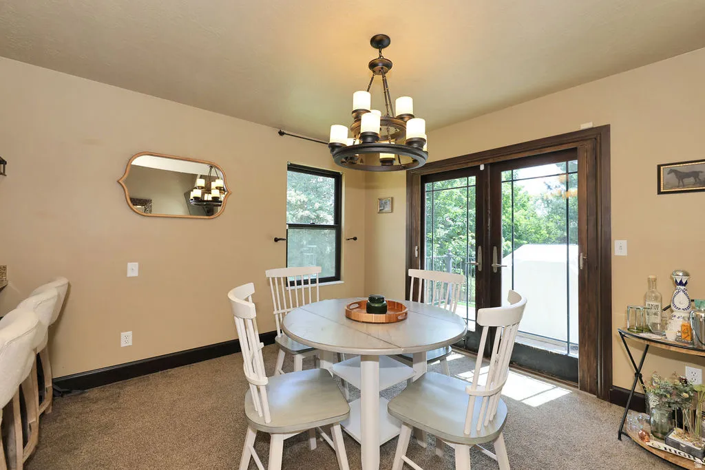 Dining area featuring an overhead chandelier, a built-in bar, and glass doors with exterior access