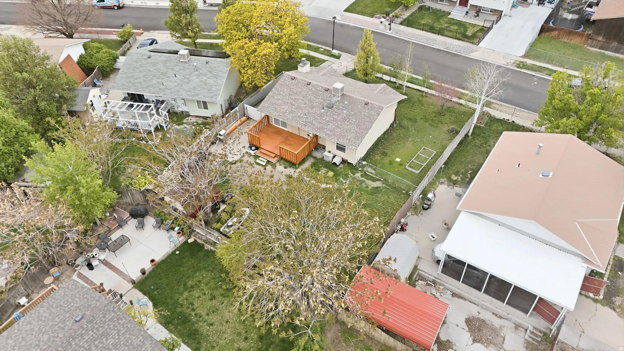 Property featuring a light-colored roof, a wooden deck, and a fenced backyard