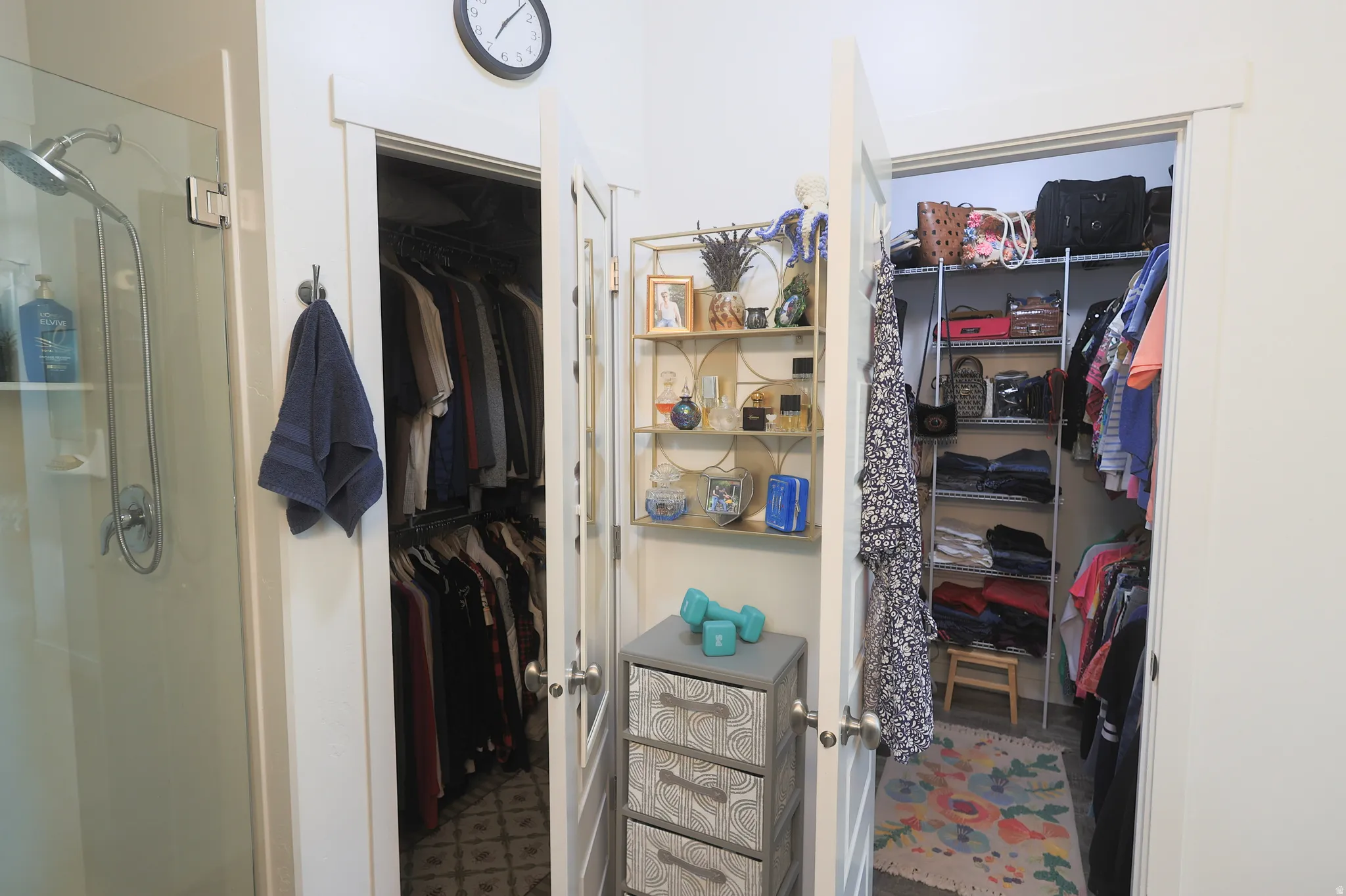 Two open master walk in closets featuring built-in shelving