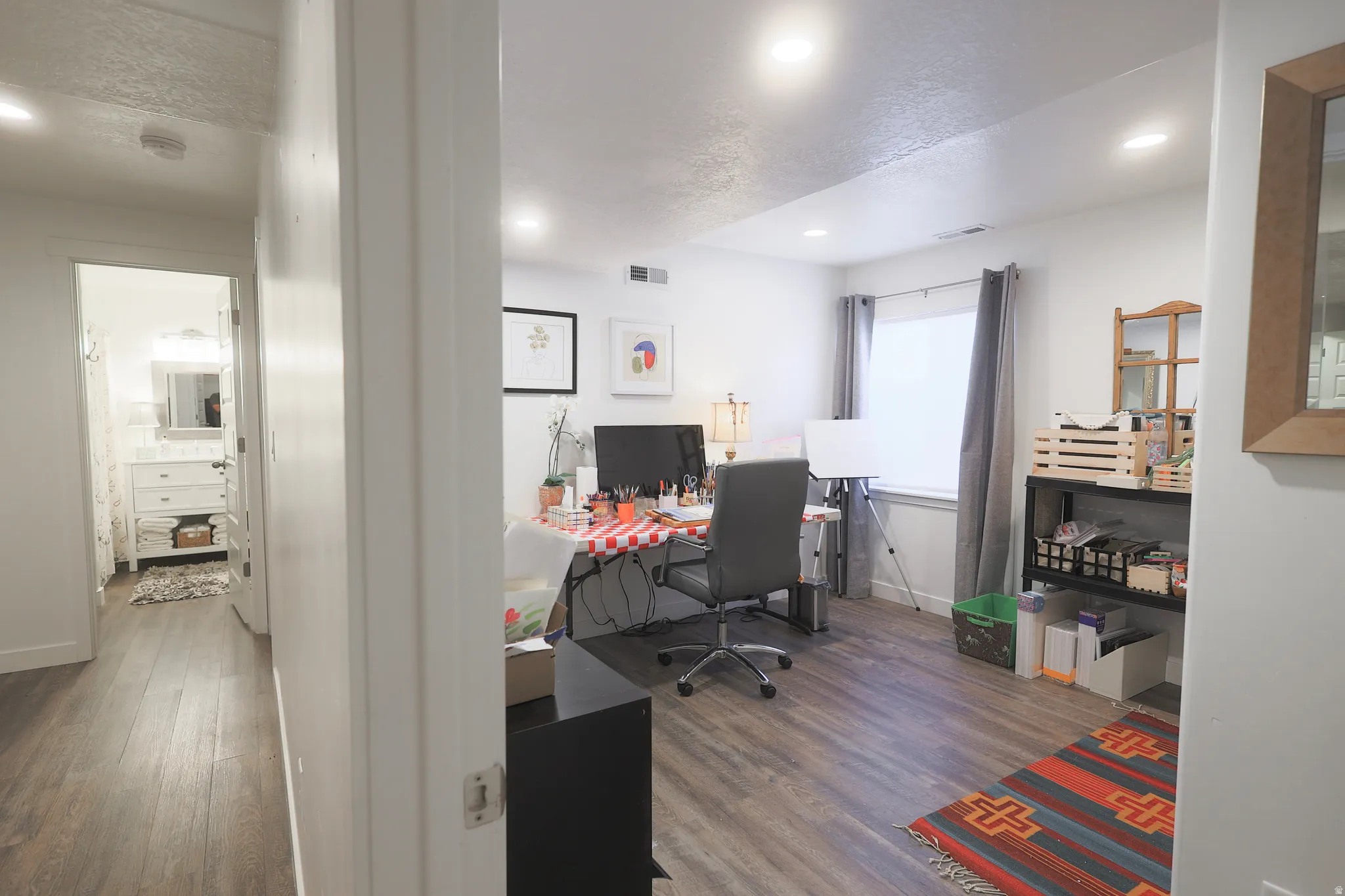 Spacious room with waterproof luxury vinyl plank flooring, recessed lighting, and a window with shade