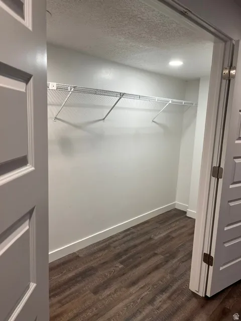Walk-in closet featuring full shelving, hanging rods, recessed lighting, and waterproof luxury vinyl plank flooring