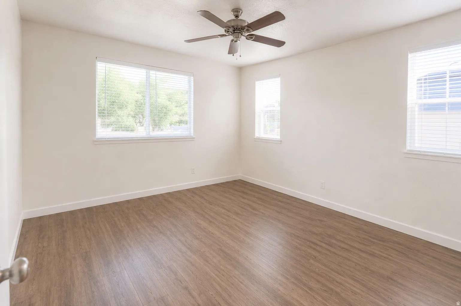 Spacious master bedroom featuring lots of light and waterproof luxury vinyl plank flooring