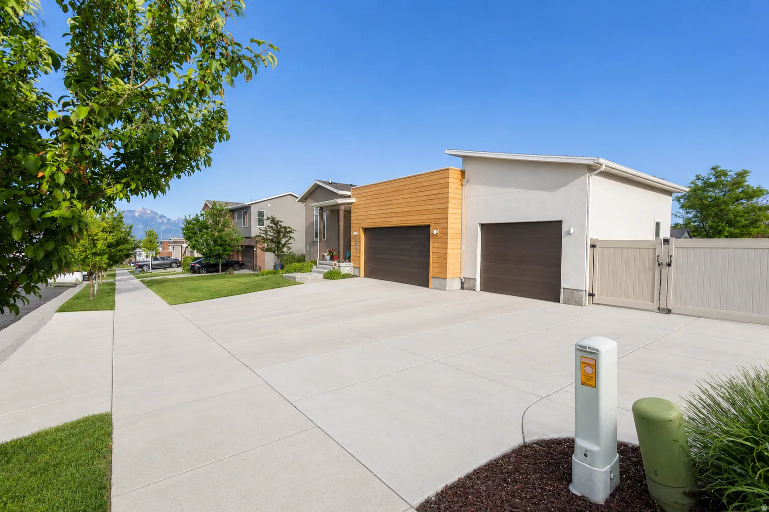 Modern architectural design featuring a wood-panel accent wall and RV parking with double entry gate.