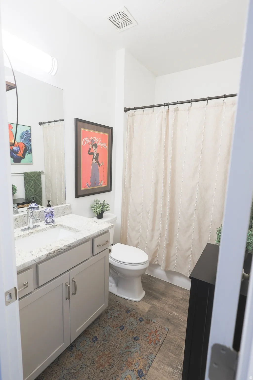 Full second Bathroom on first level featuring a light-toned vanity with a white countertop and integrated sink, a white toilet, and waterproof luxury vinyl plank flooring