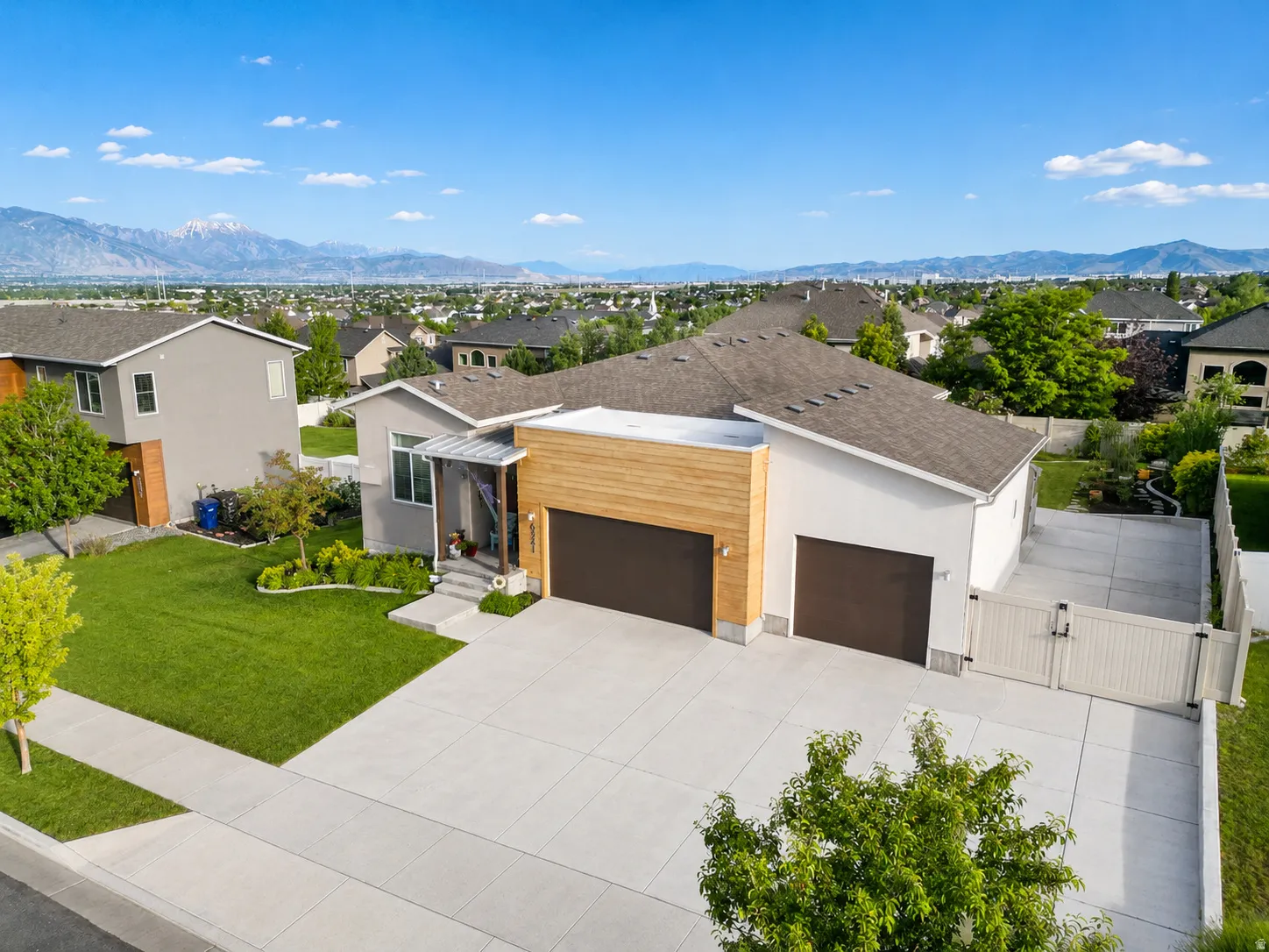 Contemporary exterior with a wood-clad three-car garage facade. RV parking with double entry gate