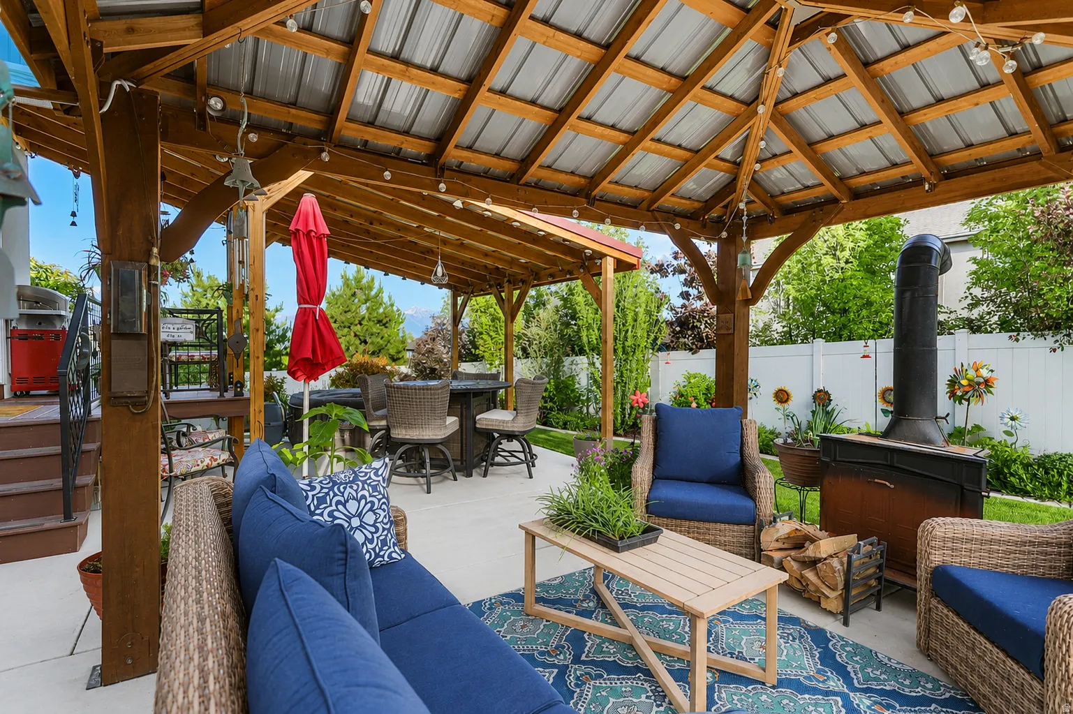 Expansive outdoor living area featuring a large wooden pergola with a corrugated metal roof