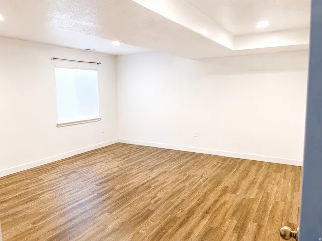 Spacious room featuring waterproof luxury vinyl plank flooring, recessed lighting, and a window