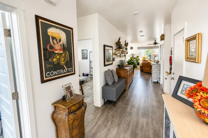 Inviting hallway entry featuring wood-finish flooring, recessed lighting, white walls, and a clear line of sight to the main living area