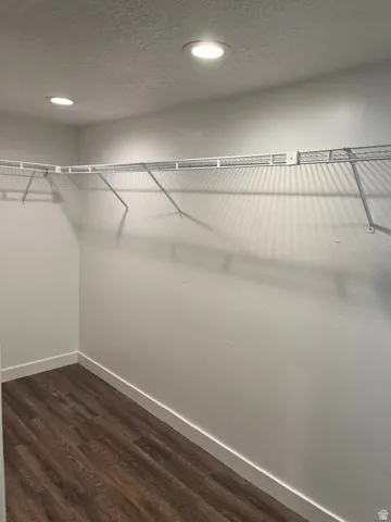 Walk-in closet featuring full shelving, hanging rods, recessed lighting, and waterproof luxury vinyl plank flooring