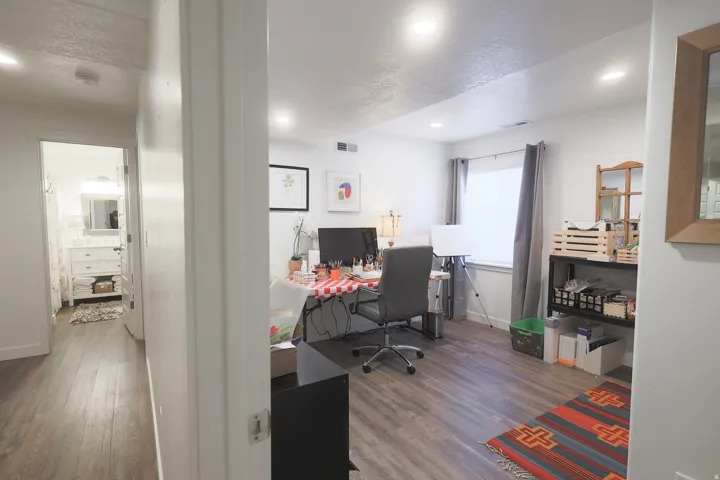Spacious room with waterproof luxury vinyl plank flooring, recessed lighting, and a window with shade