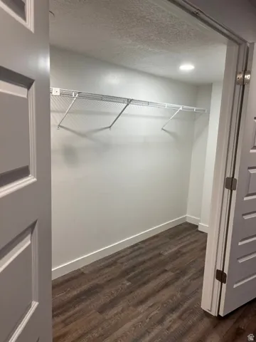Walk-in closet featuring full shelving, hanging rods, recessed lighting, and waterproof luxury vinyl plank flooring