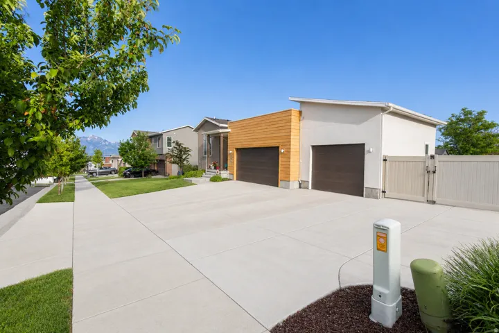 Modern architectural design featuring a wood-panel accent wall and RV parking with double entry gate.