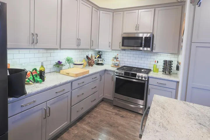 Contemporary kitchen featuring boasting 42" custom cabinets, premium granite countertops, upgraded gas appliances, and a custom pantry.