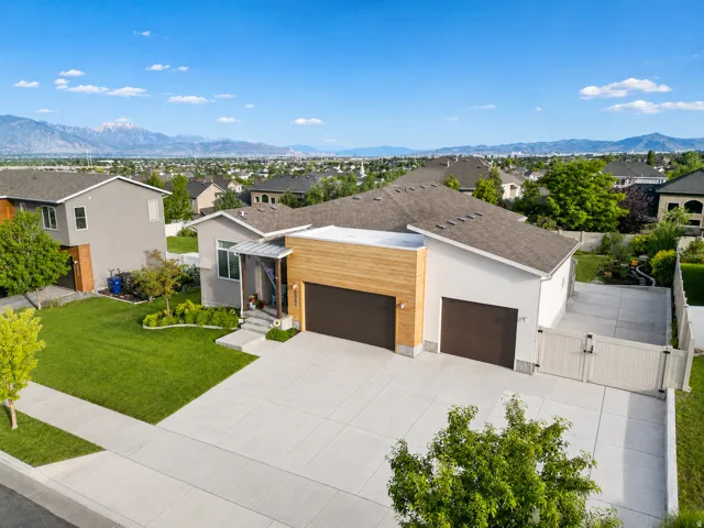 Contemporary exterior with a wood-clad three-car garage facade. RV parking with double entry gate