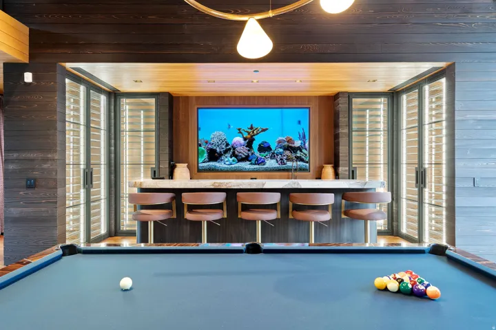Entertainment space featuring a custom bar with a stone countertop, built-in aquarium, and a billiards table