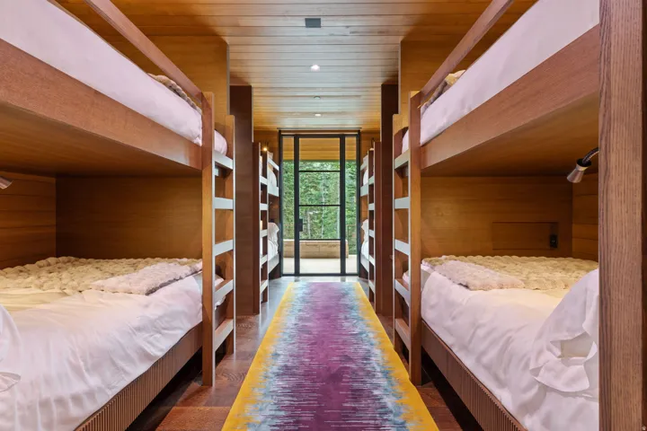Bunk room featuring built-in wooden bunk beds, recessed lighting, and individual reading lights