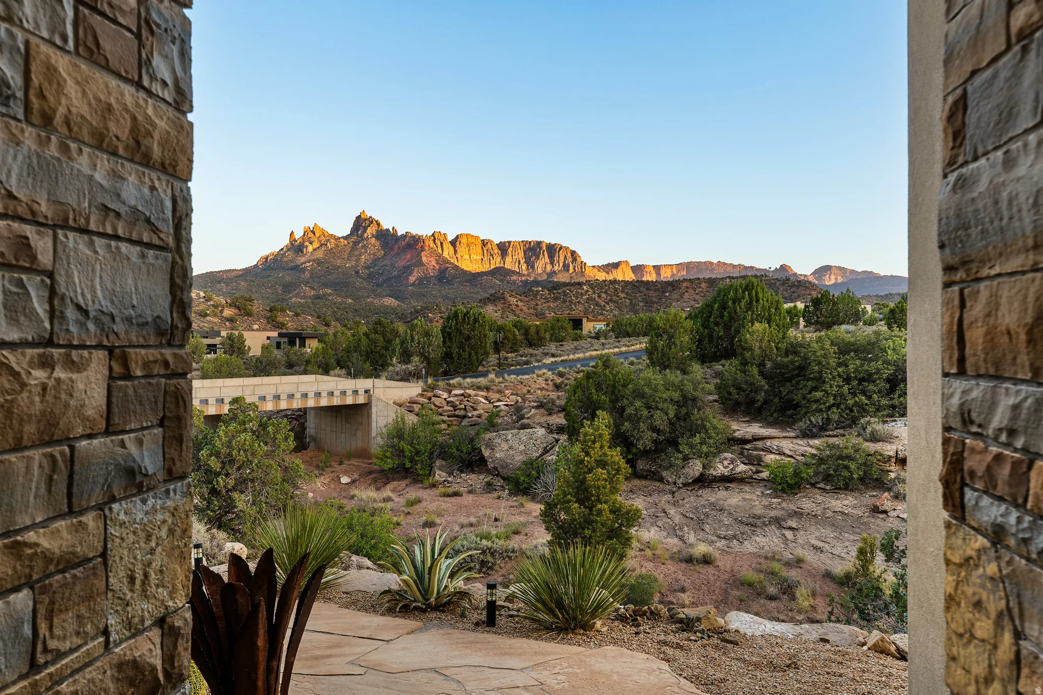 Red rock cliff views framed from the home's stone entry.