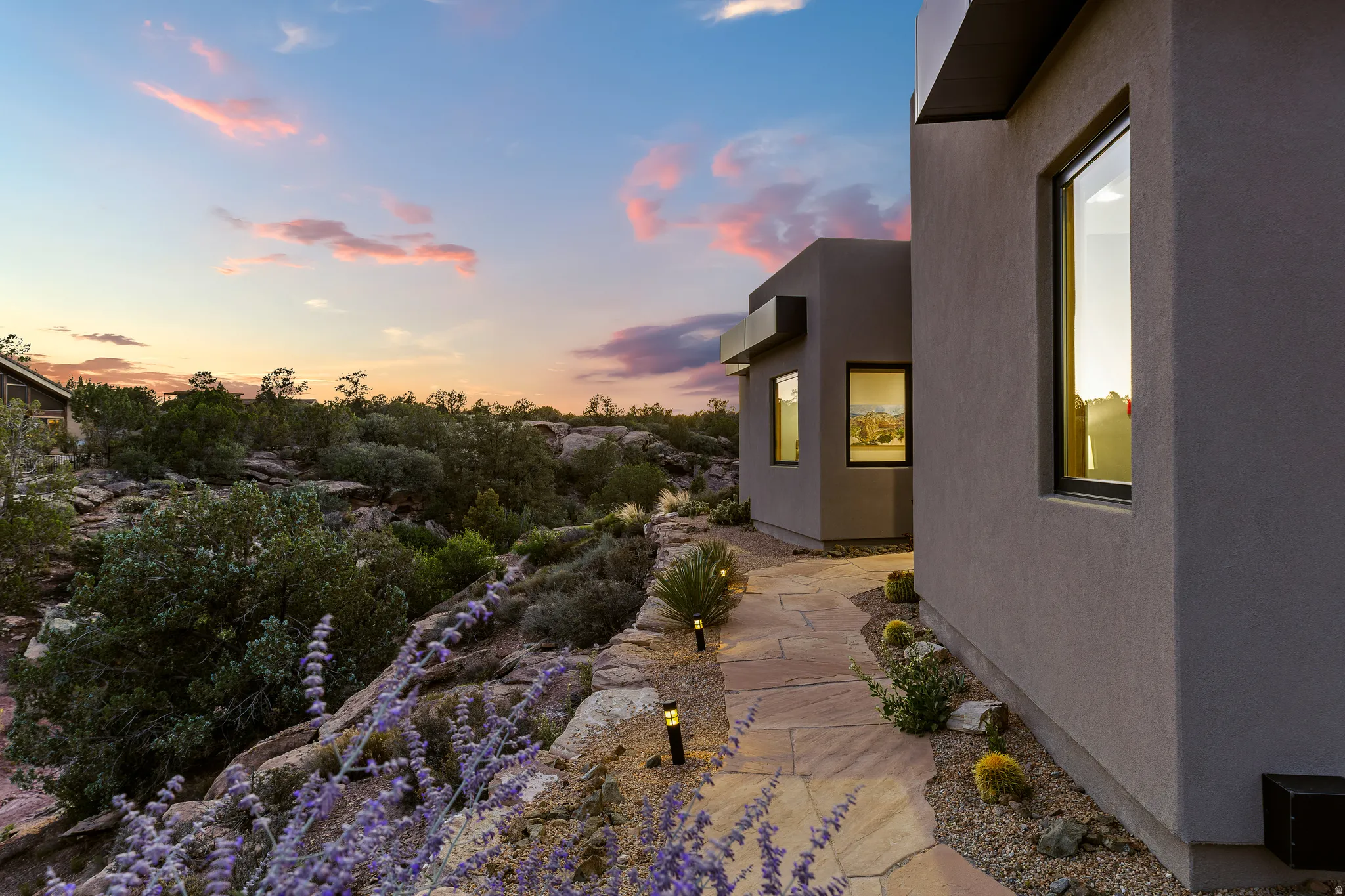 Side elevation at twilight with low-water desert landscaping.