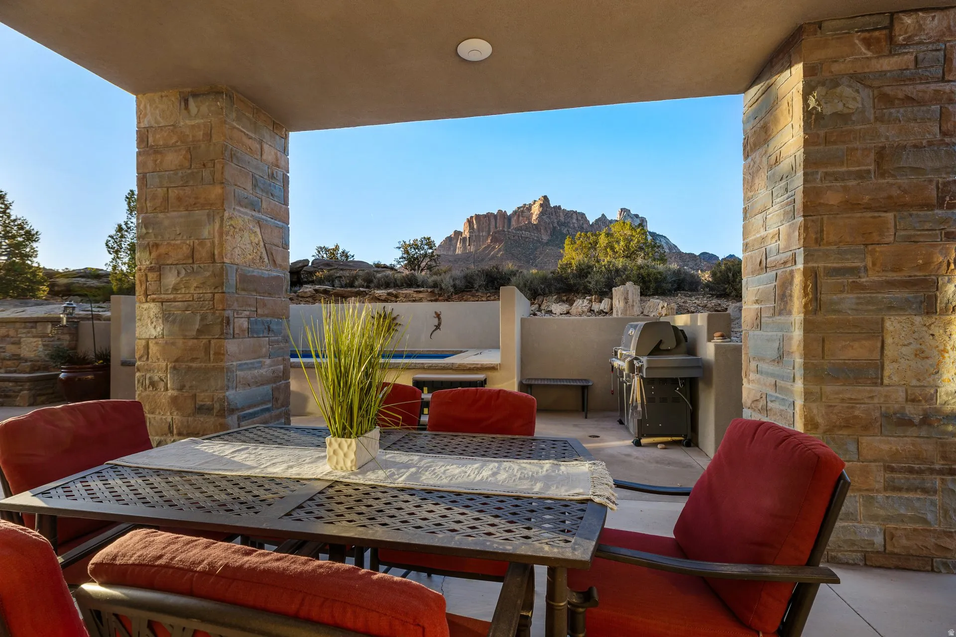 Covered patio area featuring stone-clad pillars and a textured ceiling