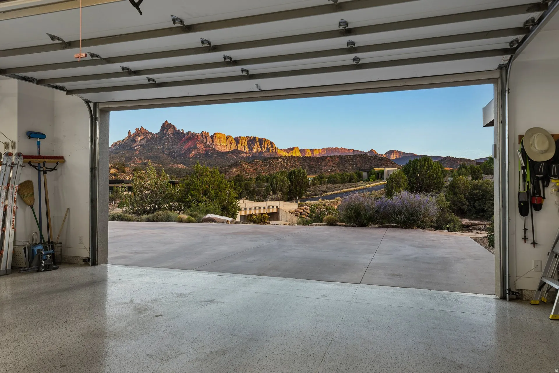 Garage interior with an open overhead door revealing a prominent mountain range backdrop