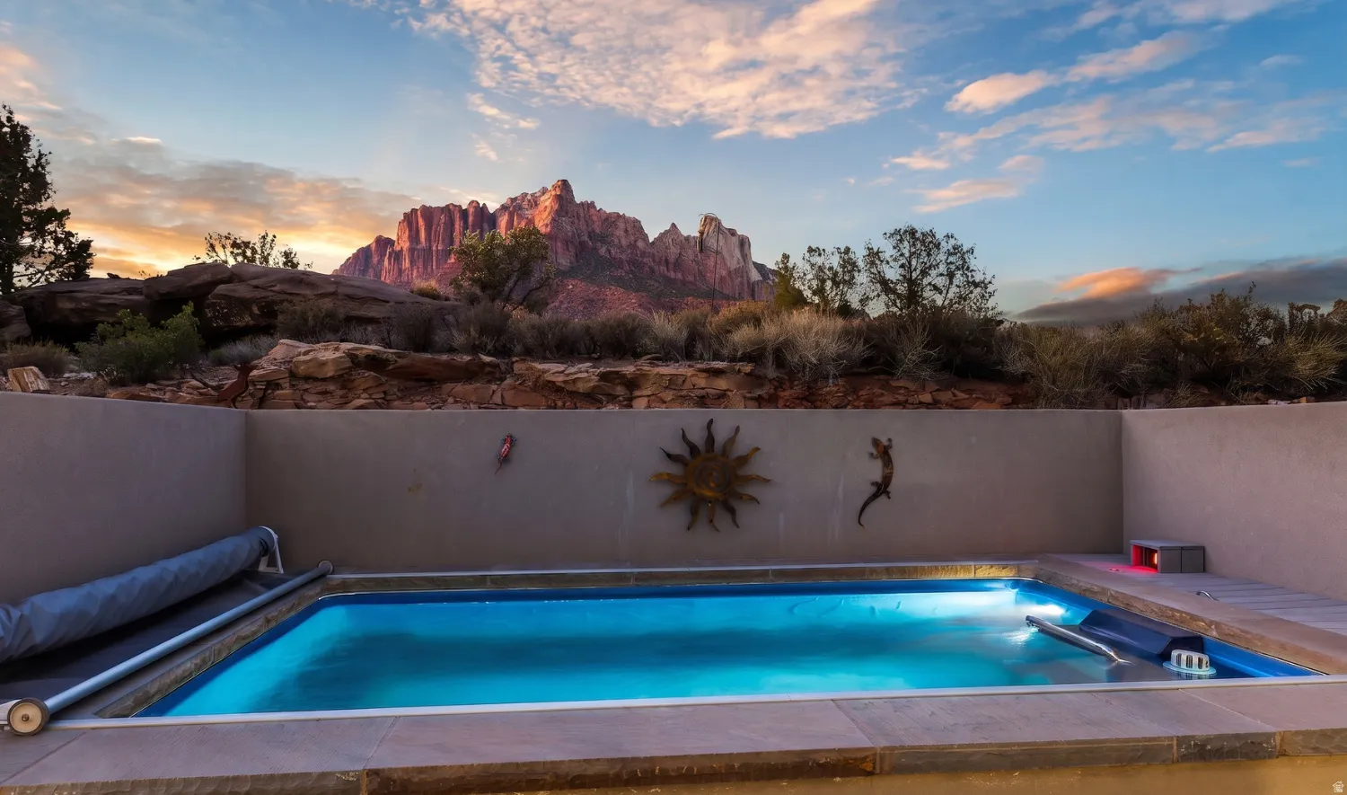Endless Pools Swim Spa set into the patio at twilight, framed by privacy walls and red rock views.