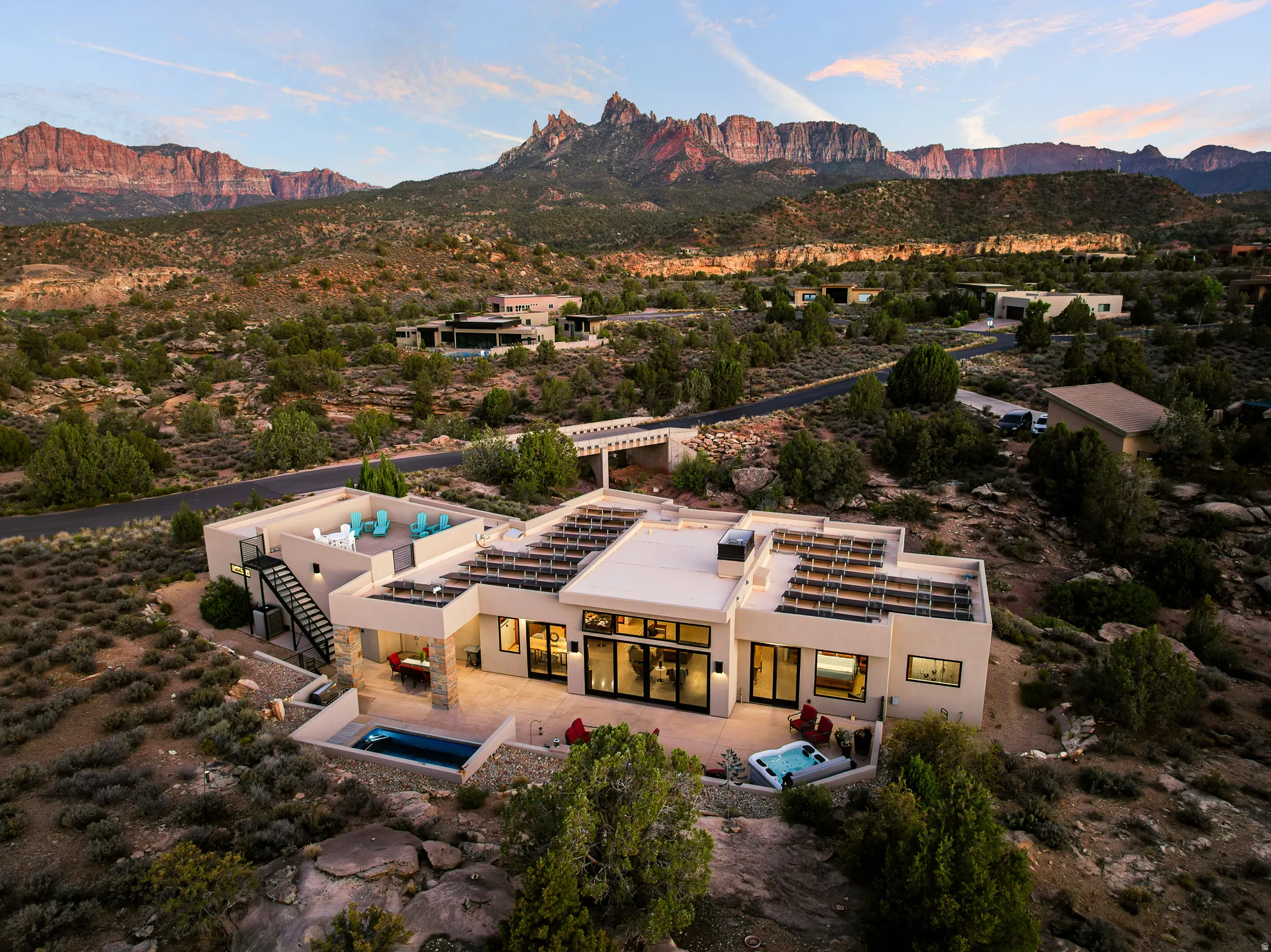 Contemporary desert architecture featuring a flat roofline and exterior staircase to a rooftop patio