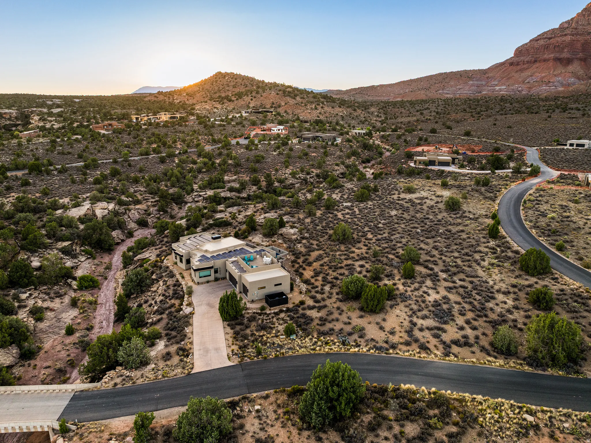 Contemporary desert dwelling featuring a tan stucco exterior, a flat roofline, and visible solar panels