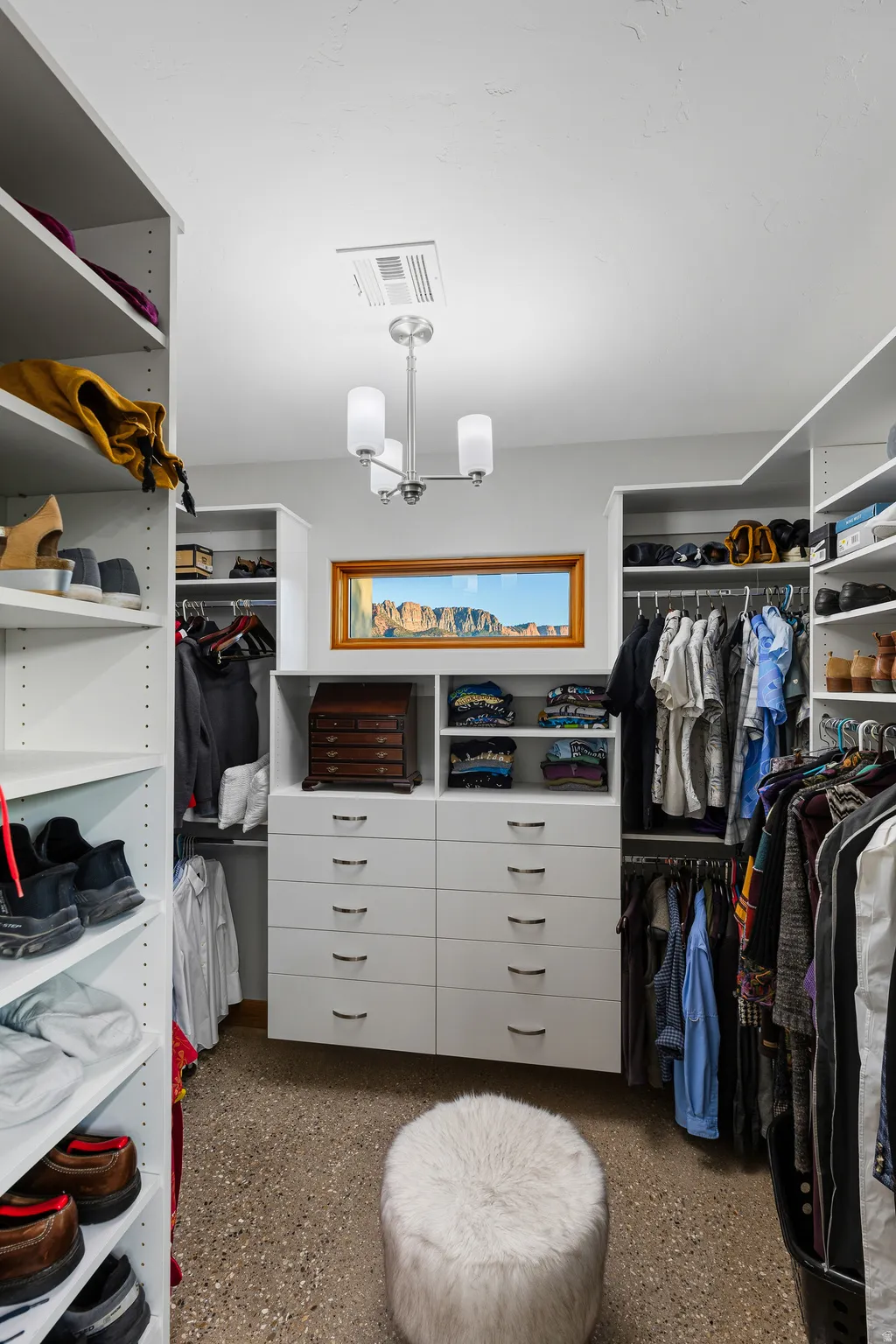Custom walk-in closet system with built-in drawers, shelving, and hanging storage.