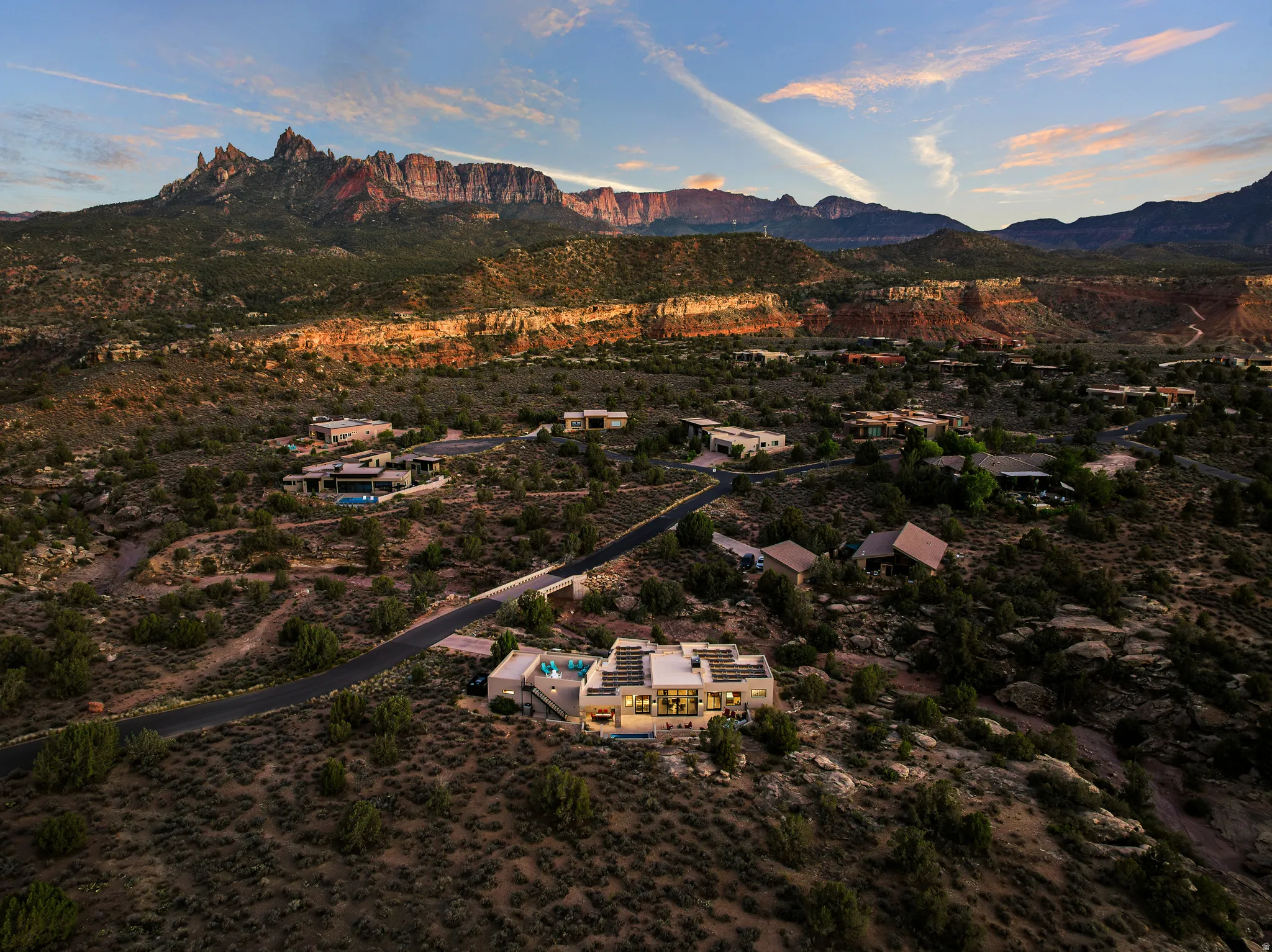 Aerial showing the home's position relative to the natural wash and surrounding cliffs.