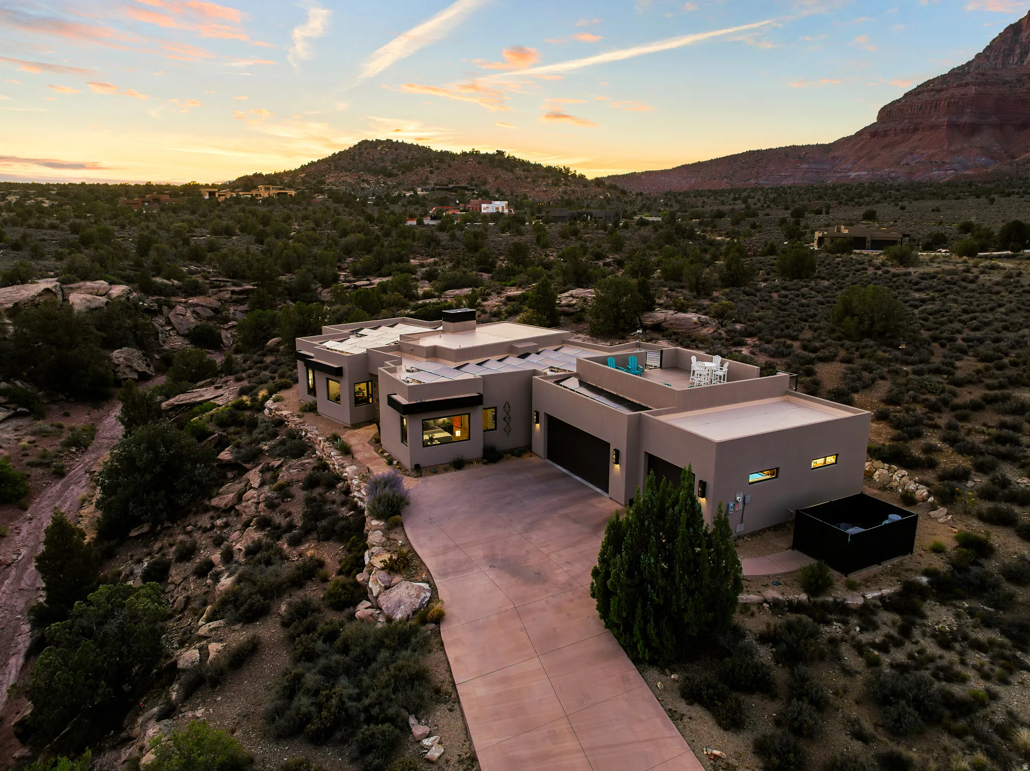 Golden-hour aerial showing the home, rear patio, and swim spa within its 0.77-acre lot.