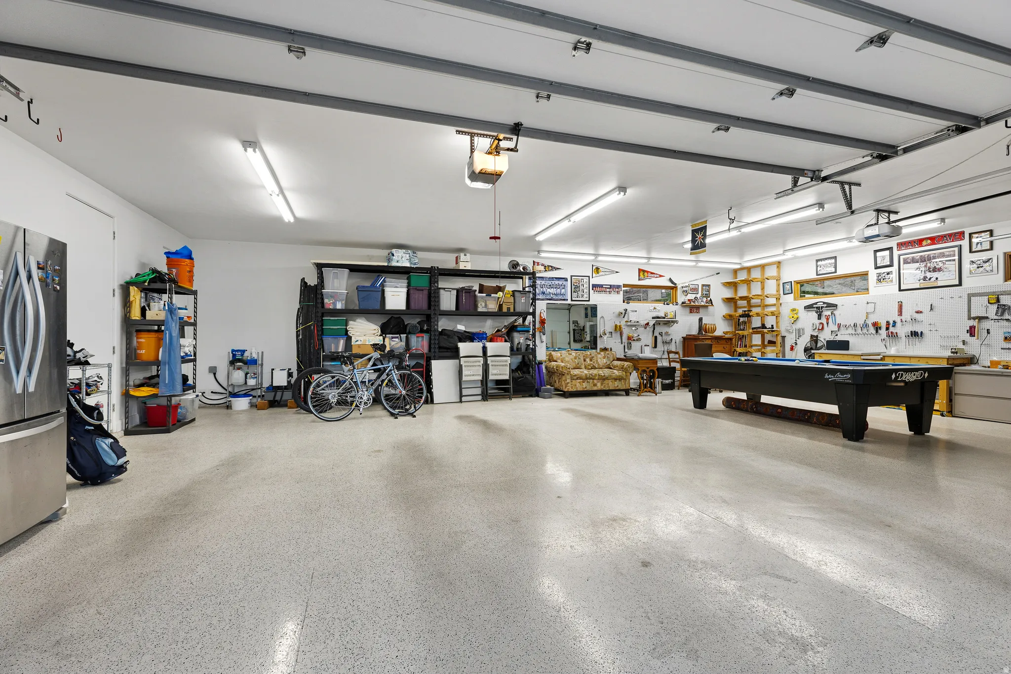 Three-car attached garage (1,144 sq ft) with finished flooring and built-in storage shelving.