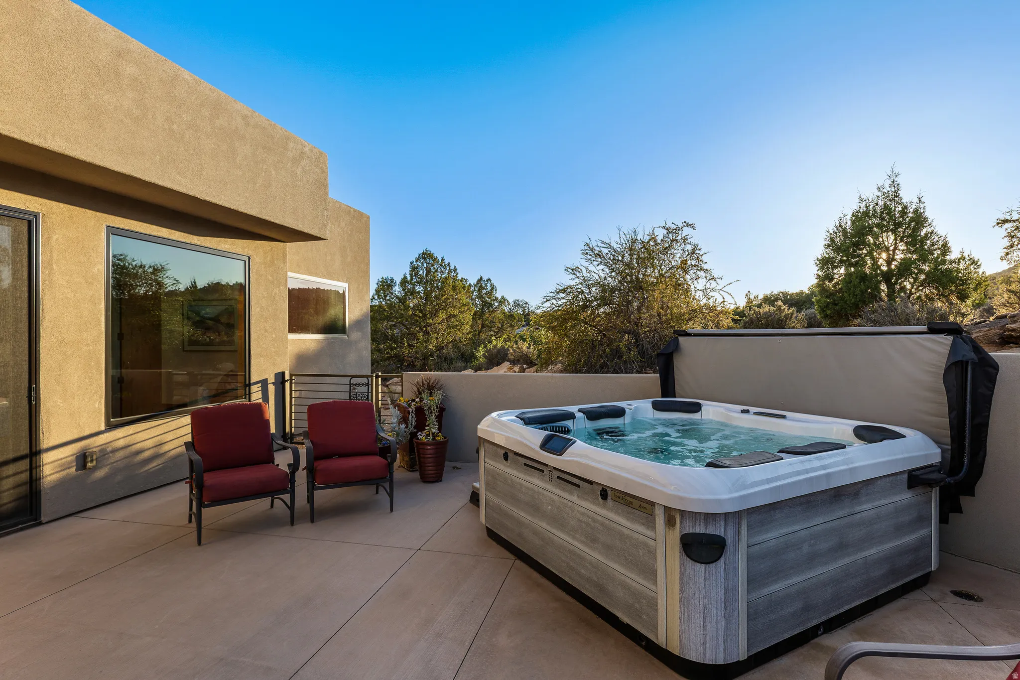 Bullfrog Spa hot tub set into the patio with open desert and cliff views.