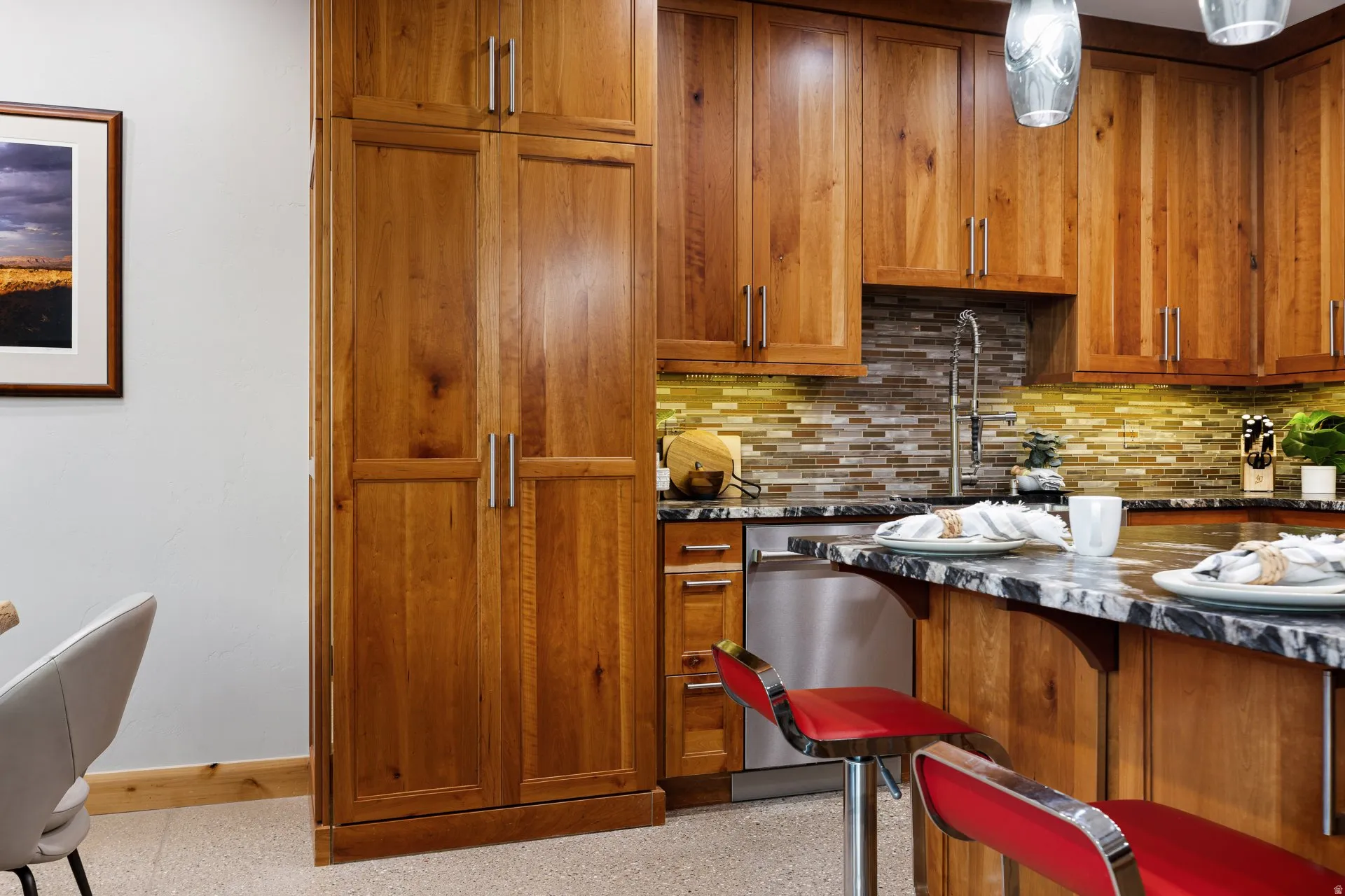 Kitchen featuring wood cabinetry, stainless steel dishwasher, mosaic tile backsplash, and stone countertops