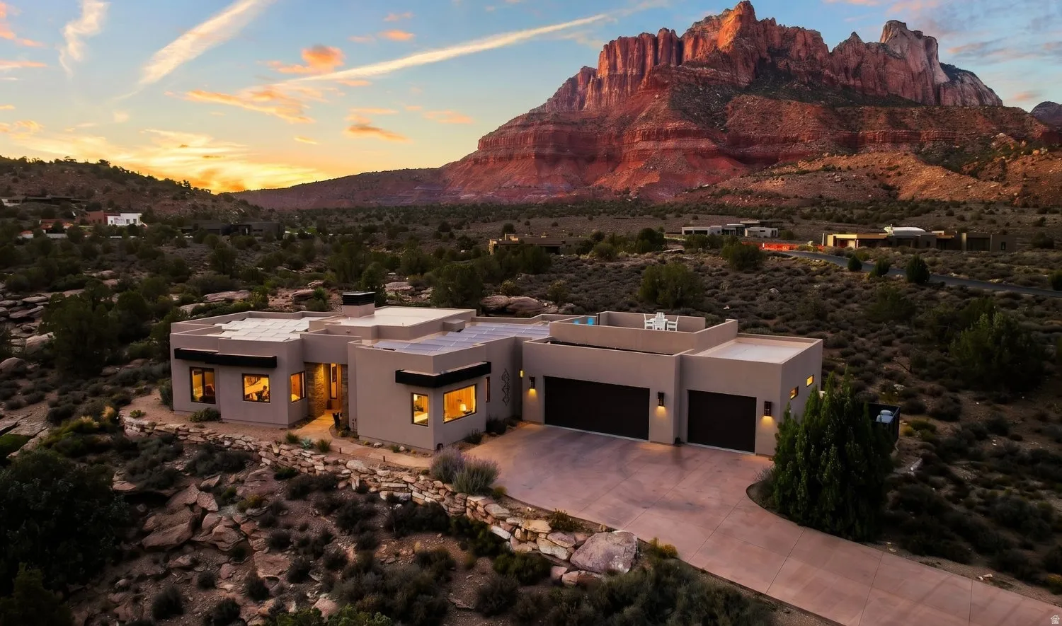 Contemporary desert residence featuring a stucco exterior, integrated garage, and rooftop patio