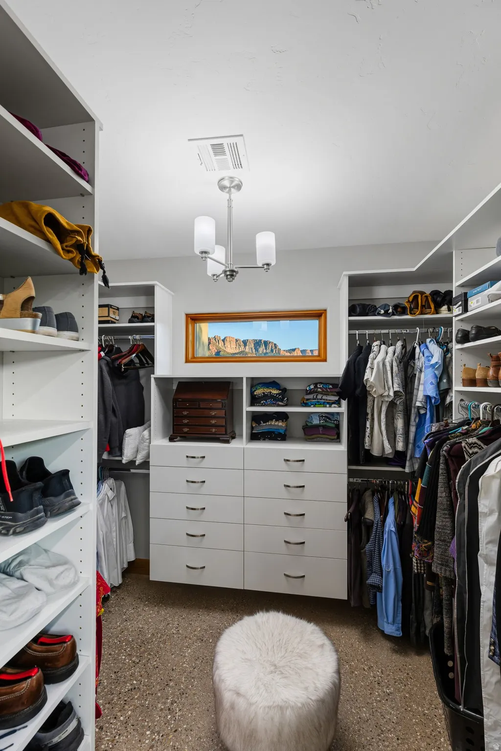 Custom walk-in closet featuring built-in cabinetry, integrated shelving, and hanging storage