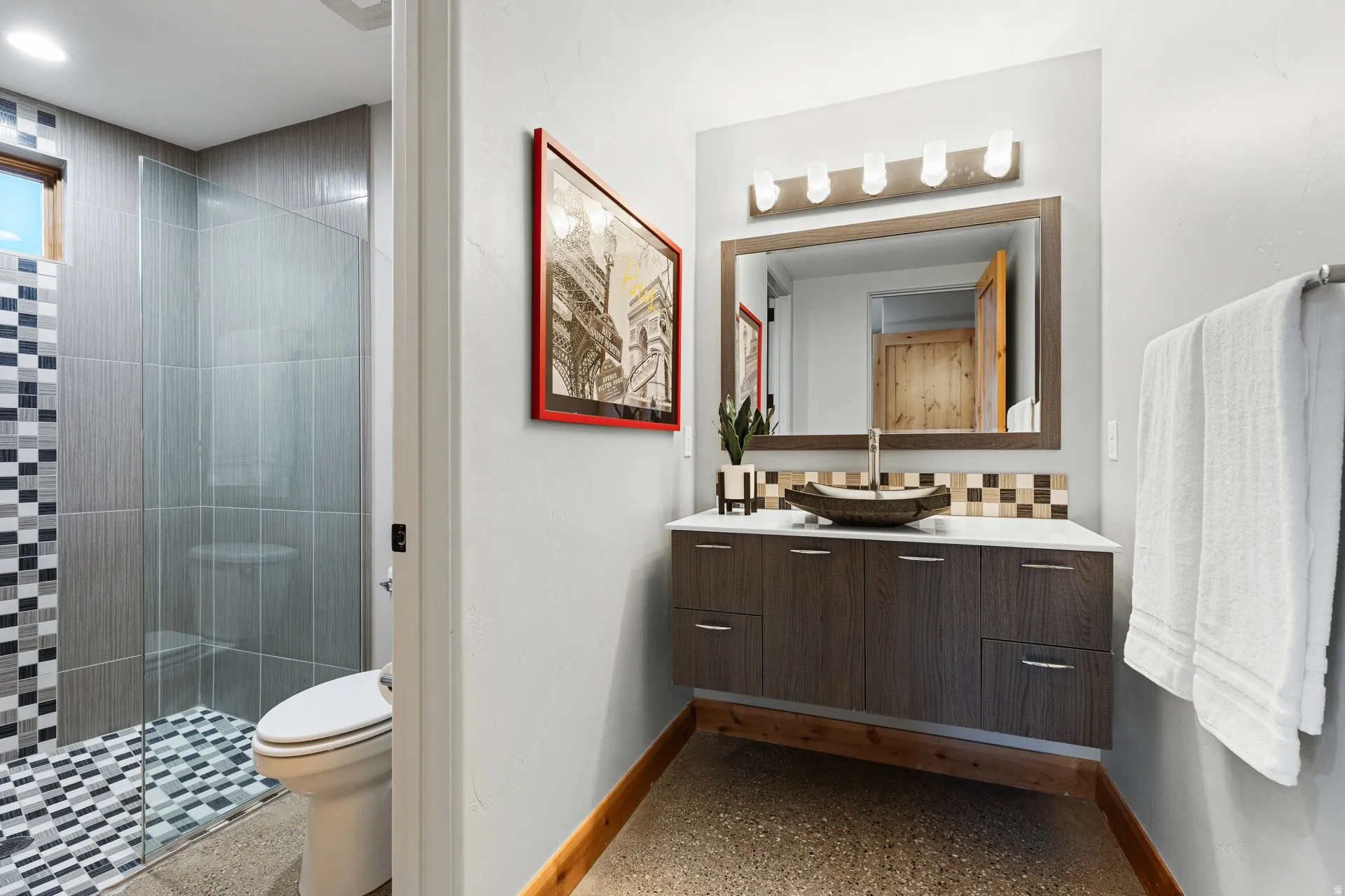 Floating vanity with a vessel sink, a full-width mirror, and overhead vanity lighting