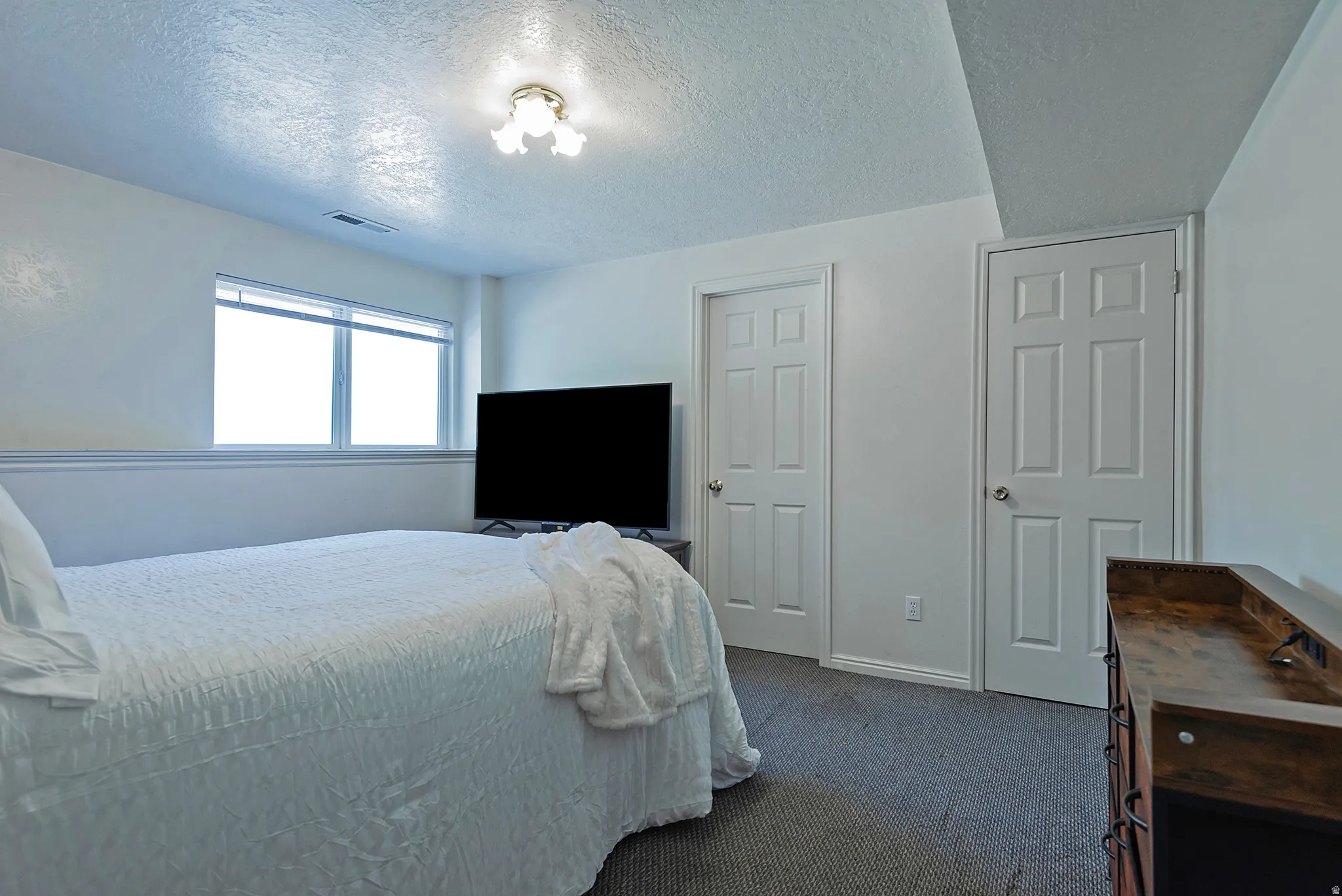 Carpeted room with a double-paned window, white trim, and two paneled doors
