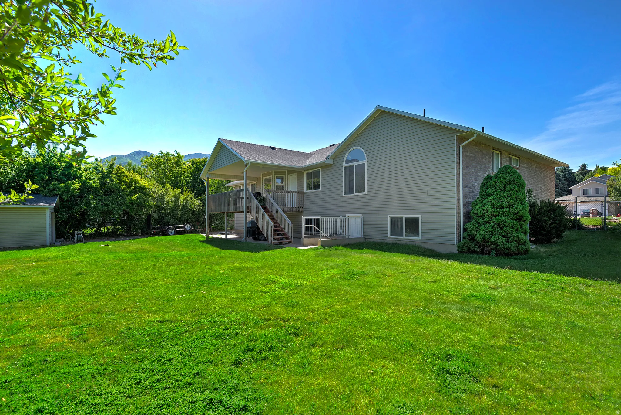 Expansive green lawn with a two-story residence featuring siding and brick accents