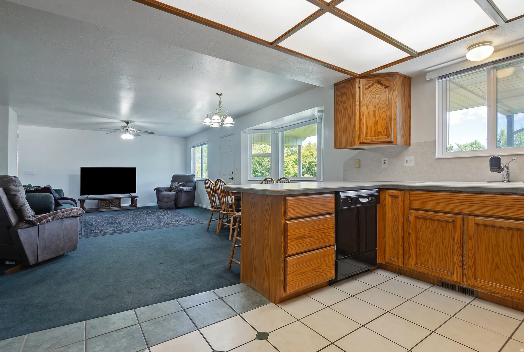 Kitchen area featuring wood cabinetry, solid surface countertops, and a built-in dishwasher