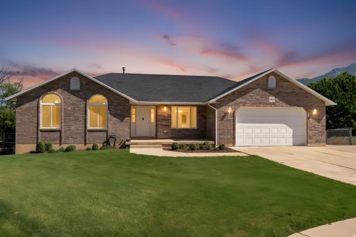 Brick exterior featuring a two-car garage with a white panel door