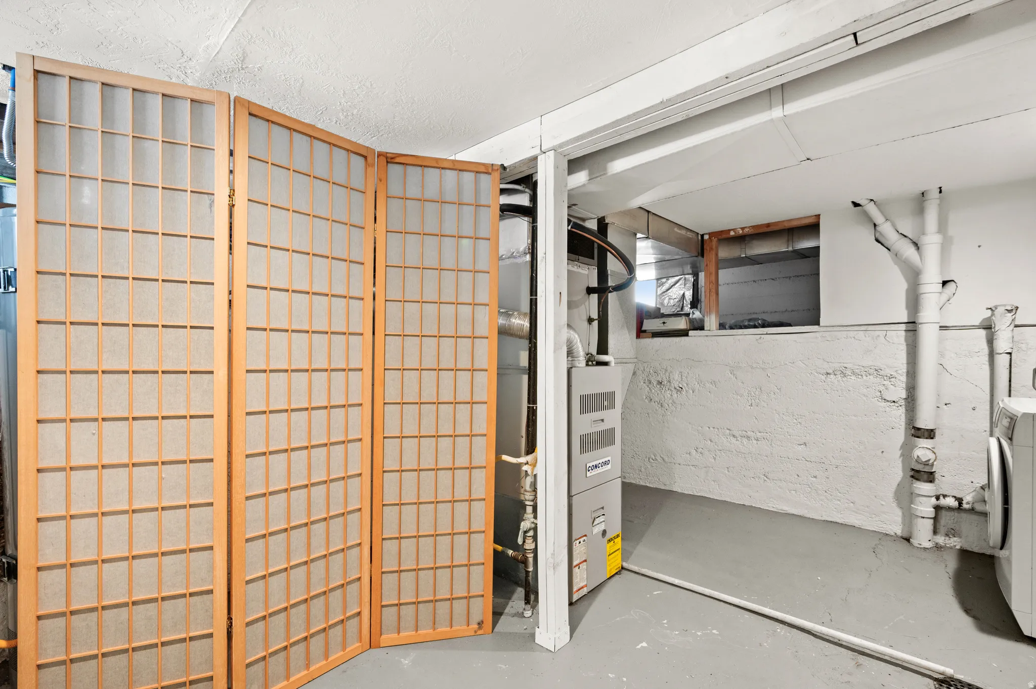 Basement utility space featuring a furnace, water heater, washer, dryer, utility sink and storage