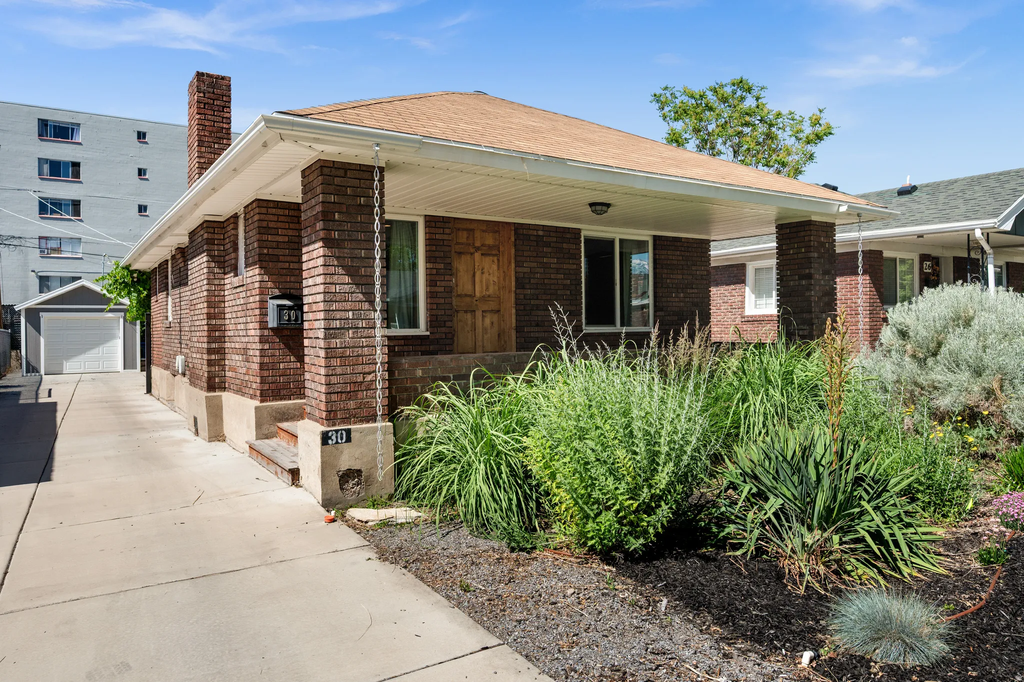 Brick Bunglaow with xeriscaped front yard with mature plants