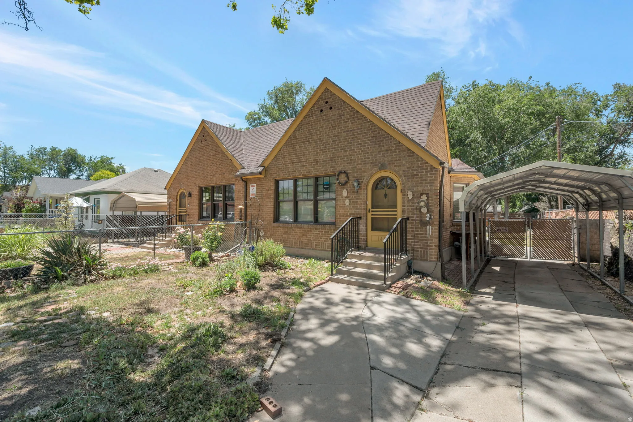 Brick exterior with a gabled roofline, a covered carport, and concrete driveway