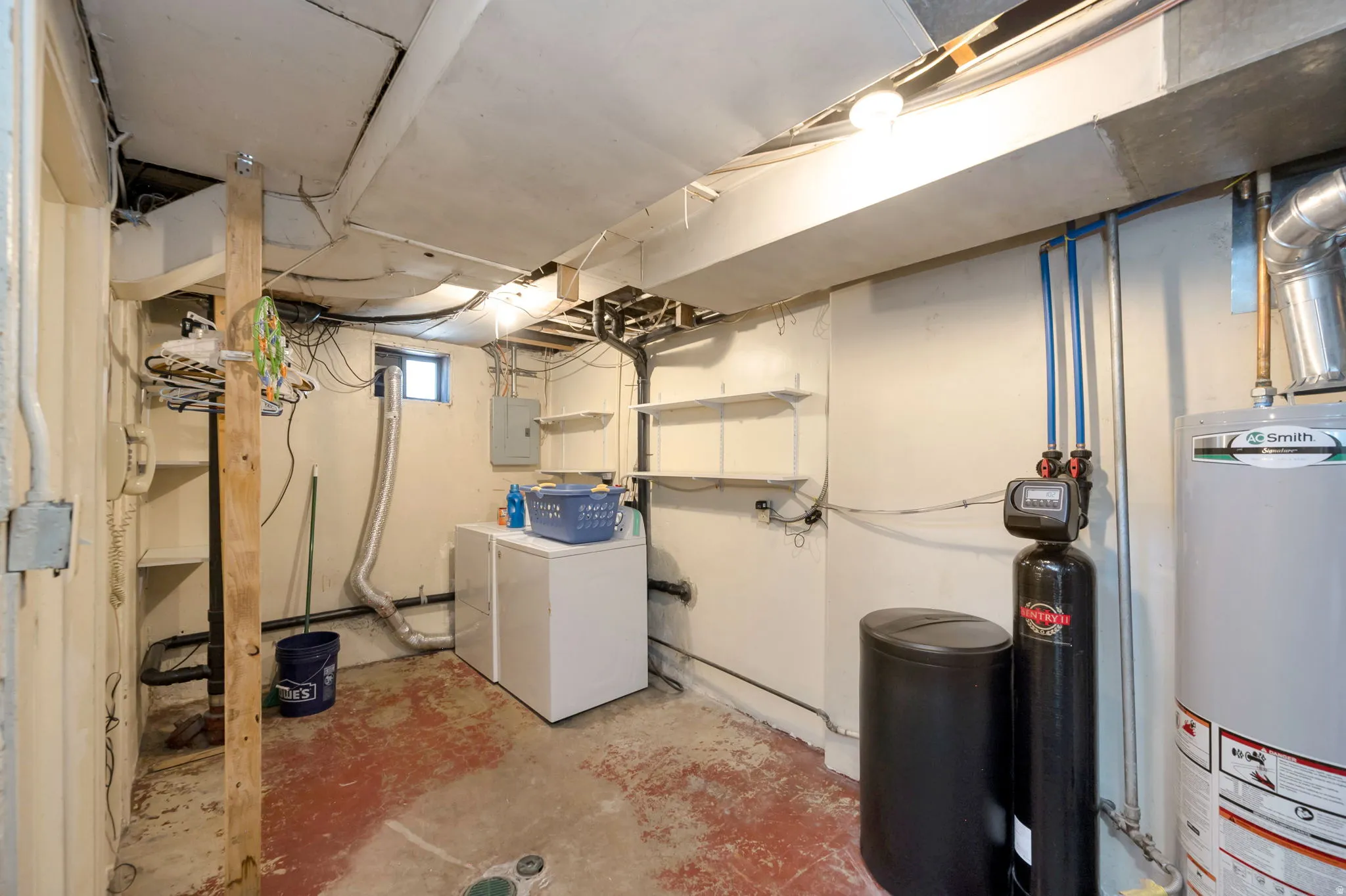 Utility room featuring a water heater, water treatment system, and built-in shelving