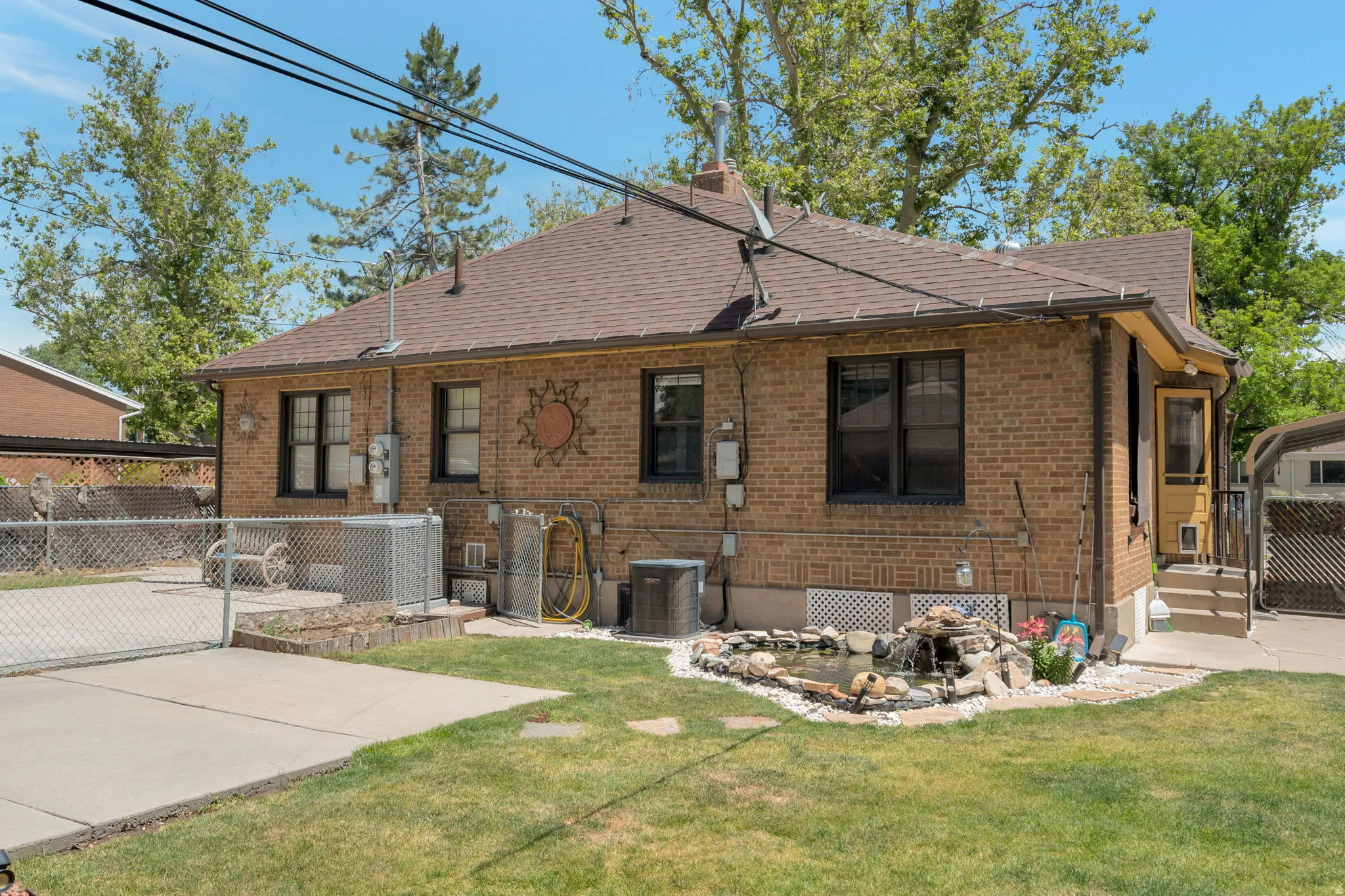 Brick exterior with a brown shingled roof and dark-framed windows