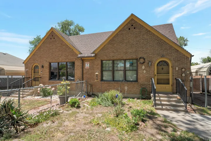 Brick facade residence featuring a gabled roofline and multiple windows