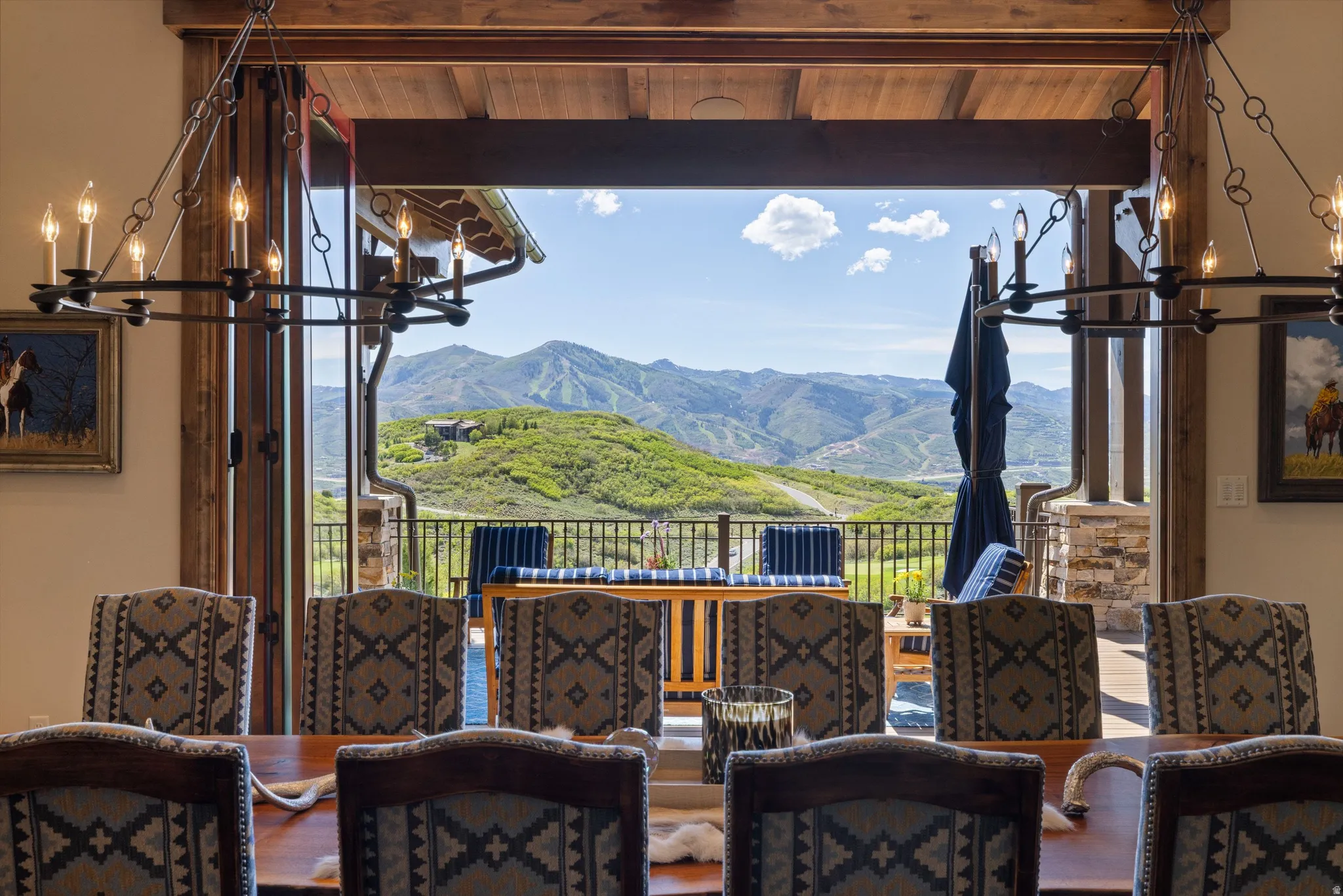 Expansive bi-fold glass doors open to an outdoor patio with mountain scenery