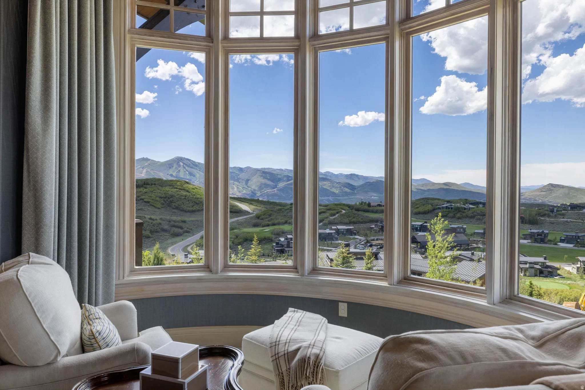 Curved bay window framing expansive mountain and distant neighborhood scenery